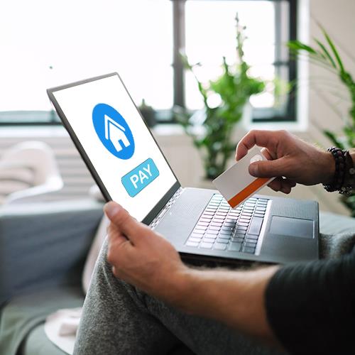 A Man Using a Credit Cards To Pay Rent on a Laptop