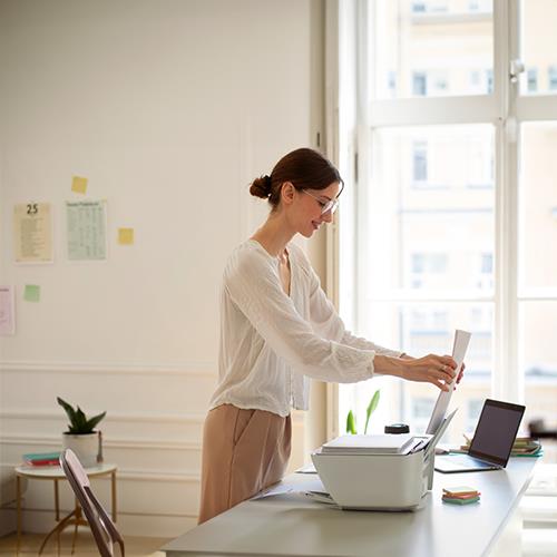 A Woman in an Office Setting Up a Printer to Print Personal Checks at Home Free