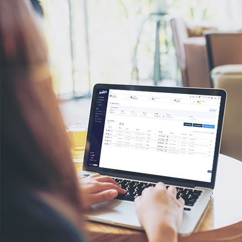 Bulk Payment Meaning – Simplifying The Financial Process A Woman Sitting in a Chair with a Laptop. She Is Studying Bulk Payment Meaning and Using Bulk Payment Method to Make Payments