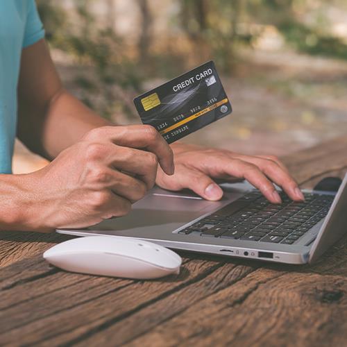 A Man Using a Laptop and a Pay Rent Using Credit Card Online, Showcasing the Convenience of Digital Payments
