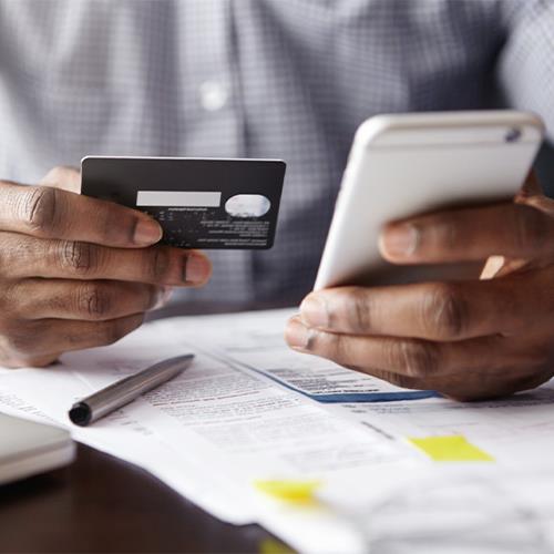 A Man Holding a Credit Card and a Notebook, Indicating the Innovative Method of Managing Payroll With Credit Card.
