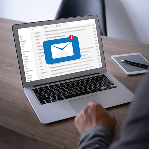 Can You Mail Checks – Ease Your Financial Transactions Person Working on a Laptop with an Email Notification, Perhaps Regarding Mail Checks, on the Screen