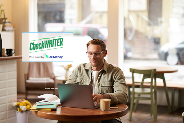 Blank Check Paper used for on-demand check printing in a cozy workspace, with a person working on a laptop.