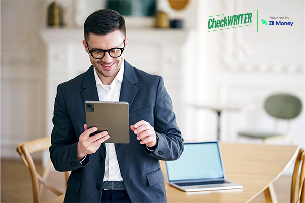 A Businessman Using a Tablet To Make a Payment. Streamline Deposit Slip Creation for Online Businesses.