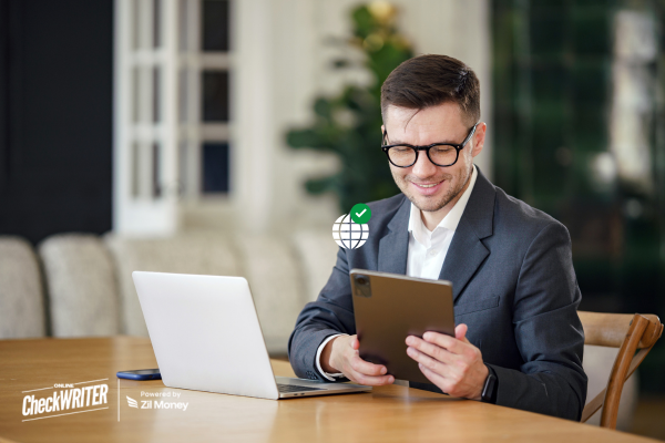 A Man Using A Laptop and Tap To Make International Payments Seamless with Fast and Secure Transactions