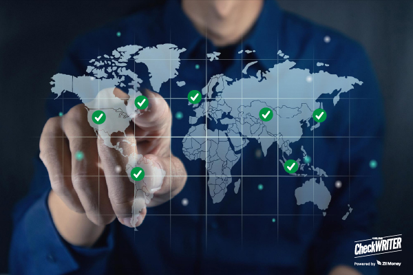 A man touches a digital world map with check marks, showing secure reach through an International Payment System.