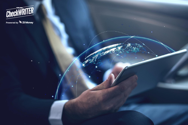 A business professional using a tablet with a digital globe overlay, highlighting the speed and reach of international payments.