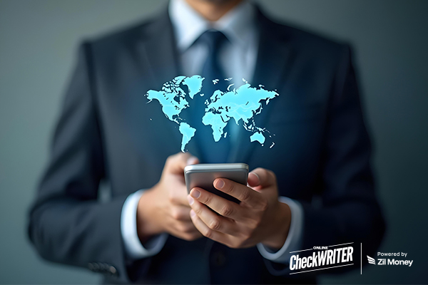 A Businessman Holding a Phone with a Glowing World Map, Symbolizing Fast International Payments and Global Money Transfer.