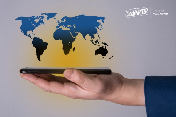 International Payments in 2025: 5 Common Problems Fixed A Hand Holds a Smartphone with a Holographic Map of the World Hovering Above It, Representing Easy International Payments.