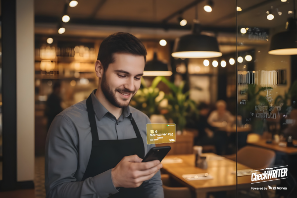 A Restaurant Worker Checks His Phone with Restaurant Employee Cards for Secure, Real-Time Staff Spending Control.