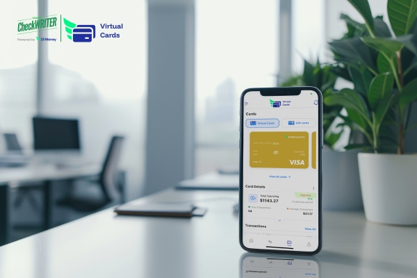 Smartphone sitting on a clean office desk displaying a virtual card dashboard with current spending details.