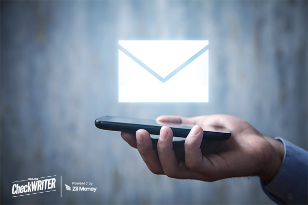 Freelancers Can Finally Mail Checks from Home: The Modern Check Mailing Revolution Hand holding a smartphone with a large, glowing envelope icon, symbolizing modern, digital check mailing on the go.