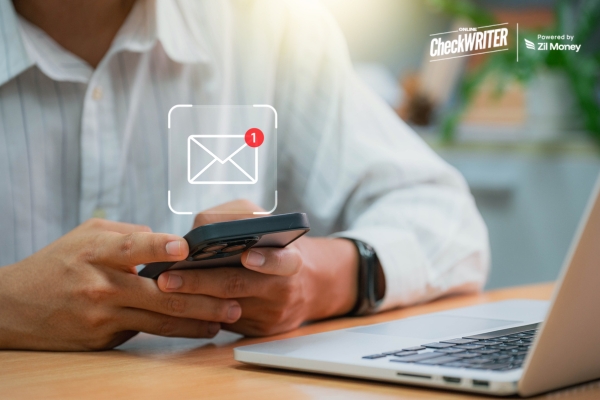 Person checking their phone for a new email notification, representing quick and reliable check mailing.