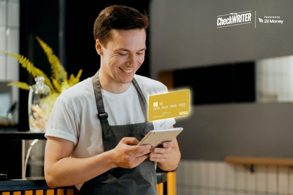 A smiling restaurant worker holds a tablet, with a gold virtual card hovering, showing the convenience of Restaurant Employee Cards.