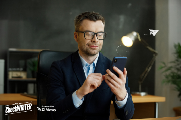 Online Check Mailing vs Manual Check Mailing — Which Works Better for You? A Man Using A Phone to Make a Payment Easily. Check Mailing for Faster, Smarter Business Payments Today